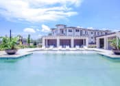 Thumbnail 48 of 60 - a large swimming pool with a mansion in the background