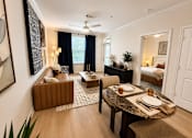 Thumbnail 6 of 41 - A dining room with a table set for two and a couch.