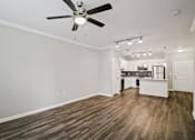Thumbnail 10 of 36 - A room with a ceiling fan and wooden flooring.