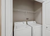 Thumbnail 17 of 36 - A white washer and dryer in a small laundry room.