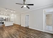 Thumbnail 11 of 36 - A room with a ceiling fan and wooden flooring.