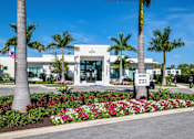 Thumbnail 72 of 78 - A white building with palm trees in front.