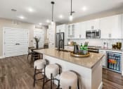 Thumbnail 65 of 94 - a kitchen with white cabinets and a large island with bar stools