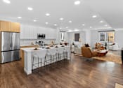 Thumbnail 7 of 45 - A modern kitchen with a dining area and a living room.
