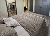Thumbnail 17 of 36 - A bedroom with a bed, a wardrobe, and a mirror.
