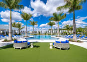 Thumbnail 42 of 78 - a rendering of a pool area with chairs and palm trees at Altis Blue Lake, Lake Worth, Florida