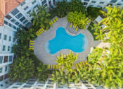 Thumbnail 2 of 35 - an aerial view of a pool in an apartment building with palm trees