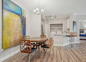 Thumbnail 14 of 36 - A dining room with a wooden table and chairs.