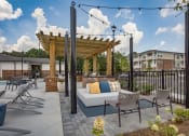 Thumbnail 34 of 46 - a patio with a couch and chairs and a pergola