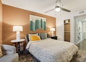 Thumbnail 11 of 28 - Atlanta, GA, Apartments with In-Unit Washer and Dryer - Virginia Highlands - Bedroom with Hardwood Floor, Area Rug, Bed, Nightstands with Lamps, Armchar, Ceiling Fan, and Spacious Closet.