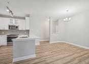 Thumbnail 24 of 36 - A kitchen with white cabinets and a white island.