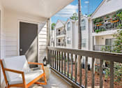 Thumbnail 10 of 28 - A balcony with a chair and table.