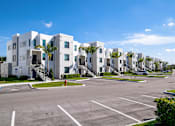 Thumbnail 67 of 78 - A row of white buildings with palm trees in front.