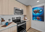 Thumbnail 14 of 78 - a kitchen with a stove and a microwave at Altis Blue Lake, Lake Worth, FL, 33467