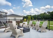 Thumbnail 29 of 46 - a patio with chairs and a firepit