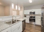 Thumbnail 2 of 37 - A kitchen with a stainless steel refrigerator, oven, and microwave.