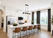 Thumbnail 2 of 40 - A modern kitchen with a white island and brown barstools.