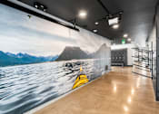 Thumbnail 34 of 94 - A wall mural of a kayak on a lake with mountains in the background.