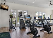Thumbnail 17 of 49 - a gym with cardio equipment and a flat screen tv
