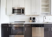 Thumbnail 11 of 25 - A modern kitchen with a black and white color scheme.