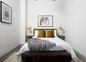 Thumbnail 15 of 25 - A bedroom with a bed, nightstands, and a painting on the wall.