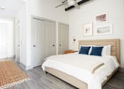 Thumbnail 23 of 25 - A bedroom with a large bed and a ceiling fan.