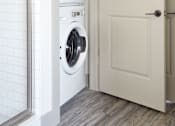 Thumbnail 25 of 25 - A white door is open to a laundry room with a washer and dryer.