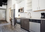 Thumbnail 6 of 25 - A kitchen with a refrigerator, oven, and sink.