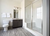 Thumbnail 24 of 25 - A white toilet sits next to a wooden cabinet in a bathroom.
