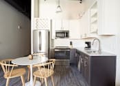 Thumbnail 2 of 25 - A kitchen with a table and chairs.