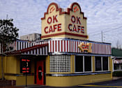 Thumbnail 29 of 39 - A yellow and red striped building with the words "OK CAFE" on top.