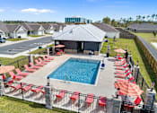 Thumbnail 31 of 53 - an aerial view of a swimming pool with red chairs and umbrellas