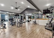 Thumbnail 10 of 53 - a gym with weights and cardio equipment and a tv on the wall