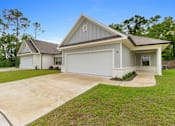 Thumbnail 50 of 53 - a white and gray house with a driveway and a lawn