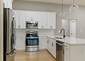 Thumbnail 41 of 53 - a large kitchen with white cabinets and stainless steel appliances
