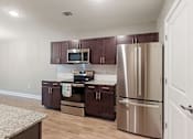 Thumbnail 16 of 53 - a kitchen with stainless steel appliances and wooden cabinets