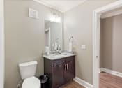Thumbnail 19 of 53 - a bathroom with a toilet and a sink and a mirror