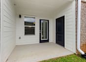Thumbnail 25 of 53 - the front porch of a white house with a black door