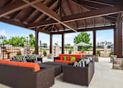 Thumbnail 25 of 36 - A patio with a brown roof and furniture.