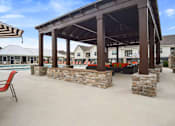 Thumbnail 27 of 36 - A covered patio area with a pool in the background.