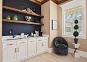 Thumbnail 16 of 36 - A kitchen with white cabinets and a black countertop.