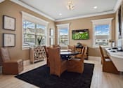 Thumbnail 14 of 36 - A living room with brown leather chairs and a black rug.