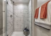 Thumbnail 19 of 25 - a shower with two towels and a sink in a bathroom