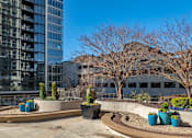 Thumbnail 29 of 32 - A courtyard with a circular design and a tall building in the background.