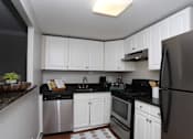 Thumbnail 6 of 32 - A kitchen with black countertops and white cabinets.