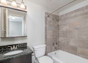 Thumbnail 18 of 32 - A bathroom with a toilet, sink, and tub.