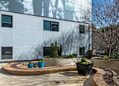 Thumbnail 27 of 32 - A modern building with a circular garden in front.