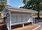 Thumbnail 18 of 23 - A white wooden bench with a white roof is in front of a building.