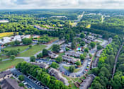 Thumbnail 22 of 23 - A bird's eye view of a residential area with houses, roads, and greenery.