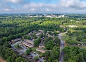 Thumbnail 23 of 23 - A bird's eye view of a small town with a mix of greenery and buildings.